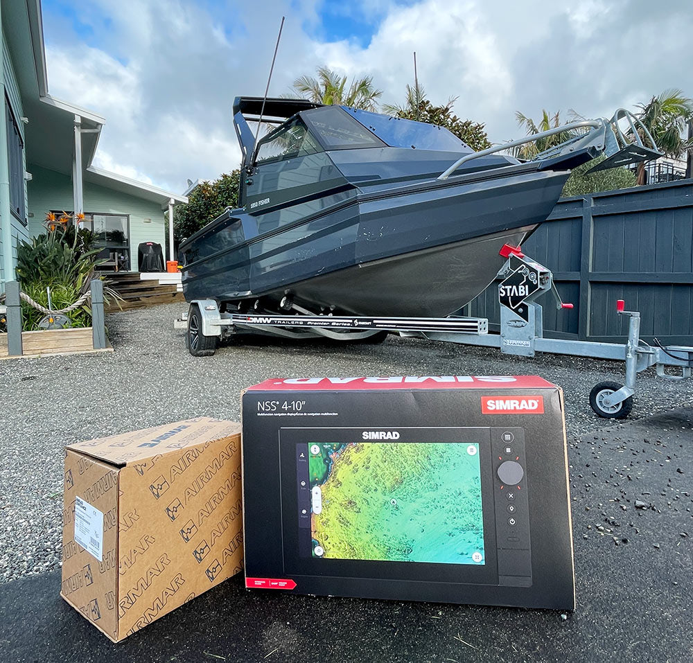 Simrad marine chartplotter on a driveway with a boat in the background
