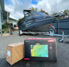Simrad marine chartplotter on a driveway with a boat in the background